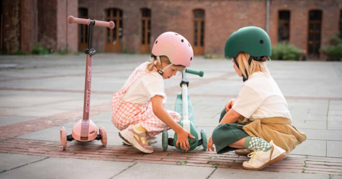 Deti jazdiace na kolobežkách s prilbou počas hry vonku