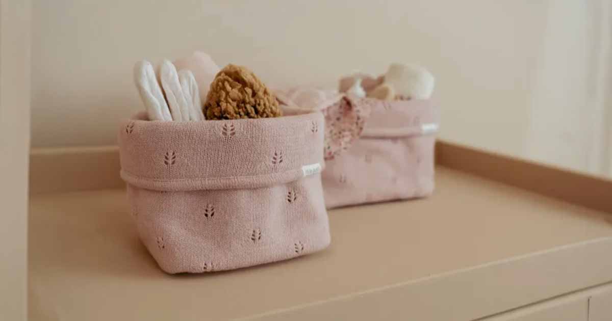 Textilné úložné boxy s doplnkami pre bábätko uložené v detskej izbe, ktoré pomáhajú udržať poriadok a vytvárajú pokojné, harmonické prostredie